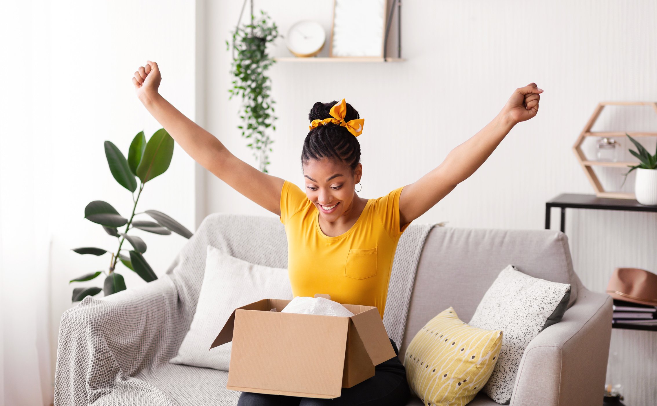 Excited black lady unboxing parcel after online shopping